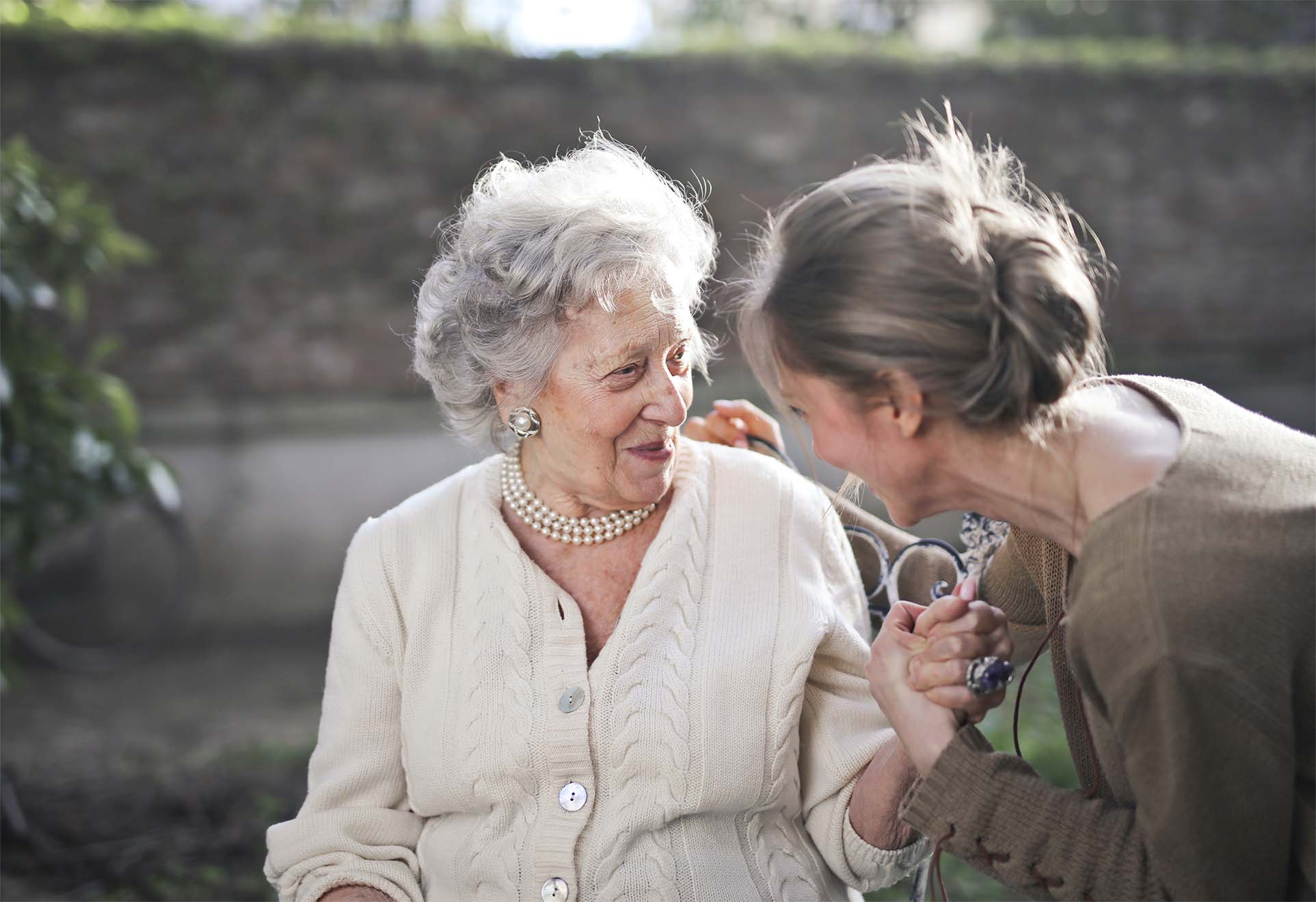 woman smiling with elderly relative in garden